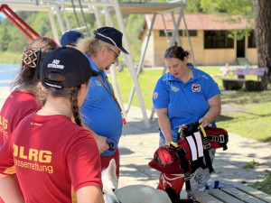 Anika und Lars, die die Ausbildung in Italien absolvieren erklären was bei einer Schwimmweste für einen Wasserrettungshund zu beachten ist.